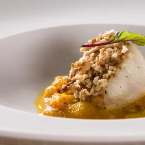 Peixe em crosta de castanha, purê de abóbora e molho de champagne